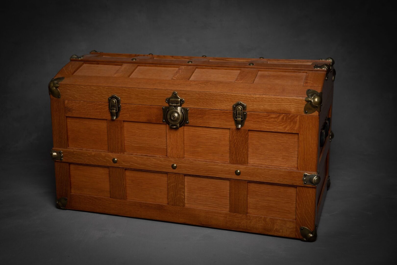 A wooden trunk with metal handles and two locks.