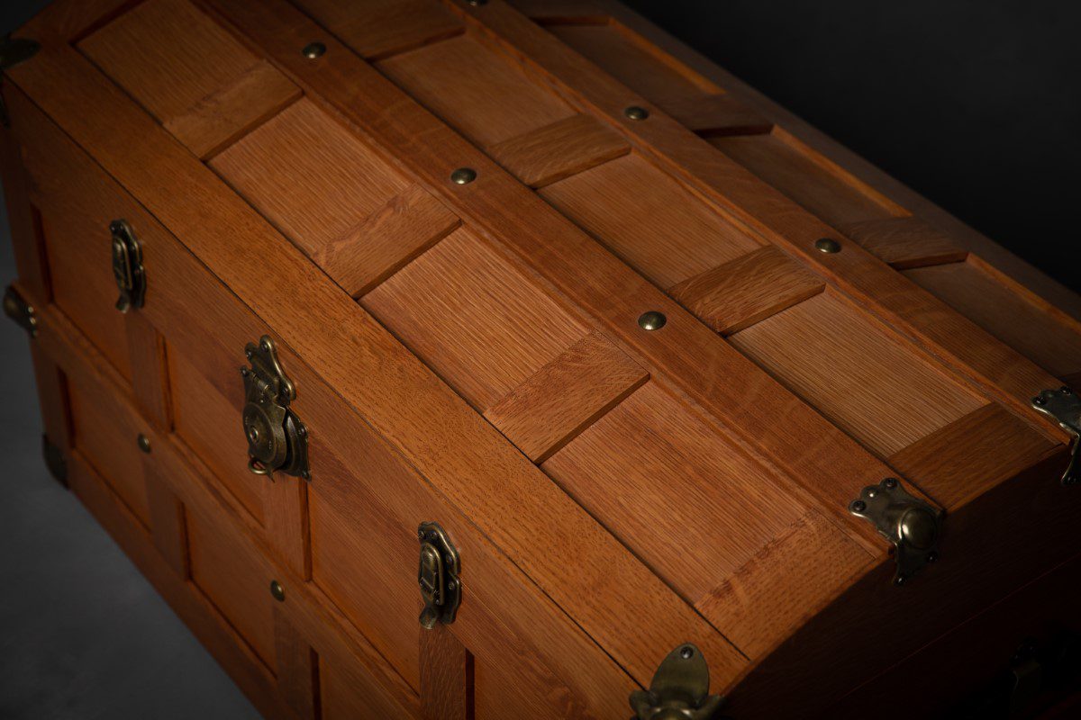 A wooden chest with metal handles and two drawers.