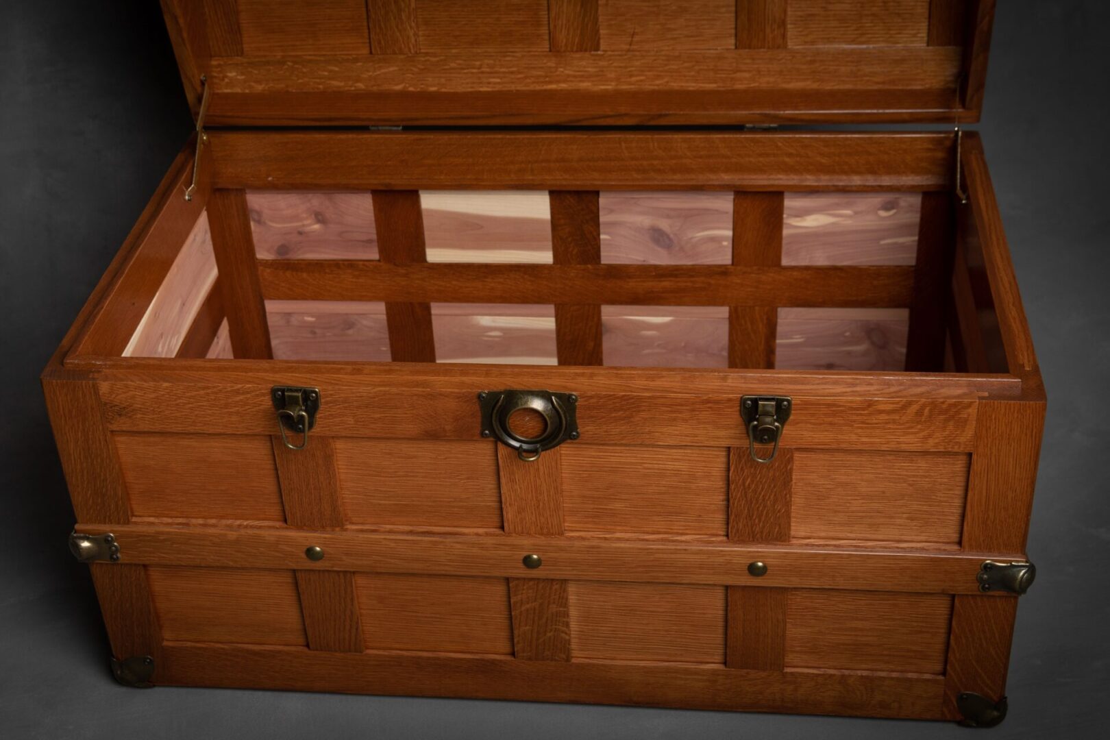 A wooden chest with brass handles and latches.