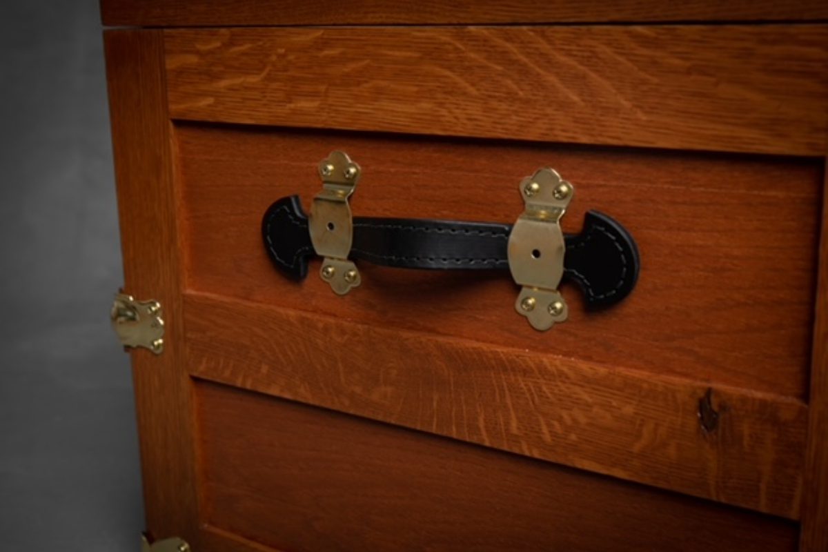 A close up of the handle on a wooden cabinet