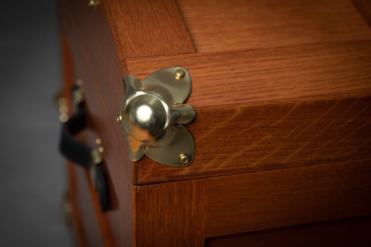 A close up of the knob on a wooden cabinet.