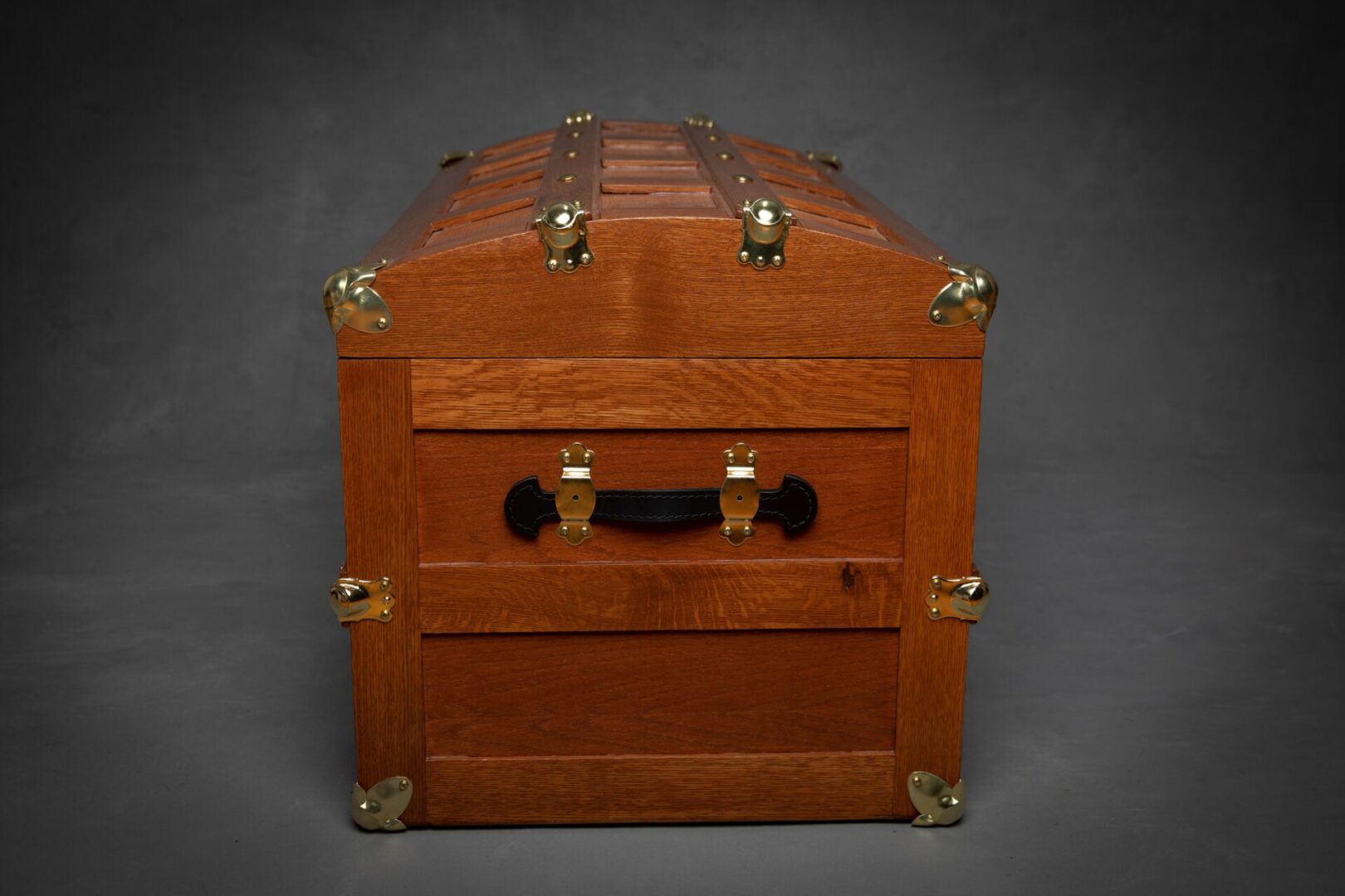 A wooden trunk with brass hardware and two drawers.