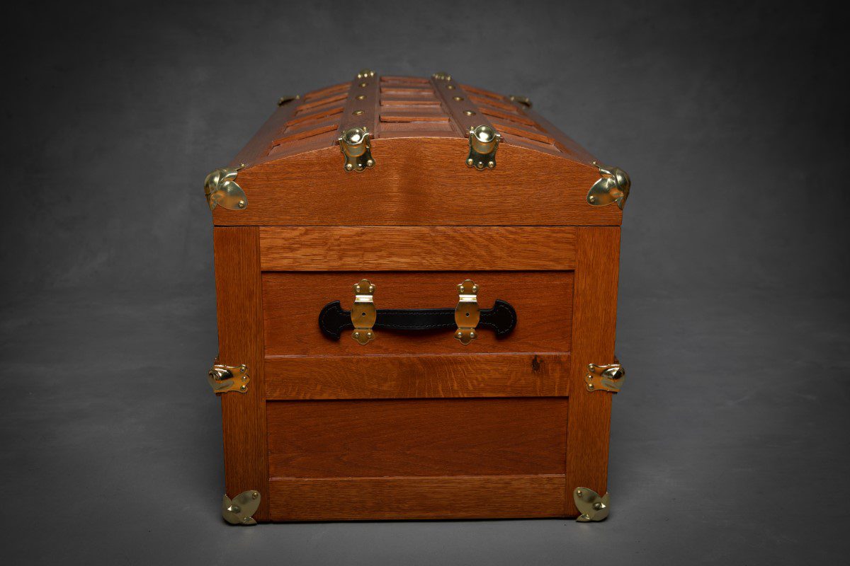 A wooden trunk with two drawers and brass hardware.