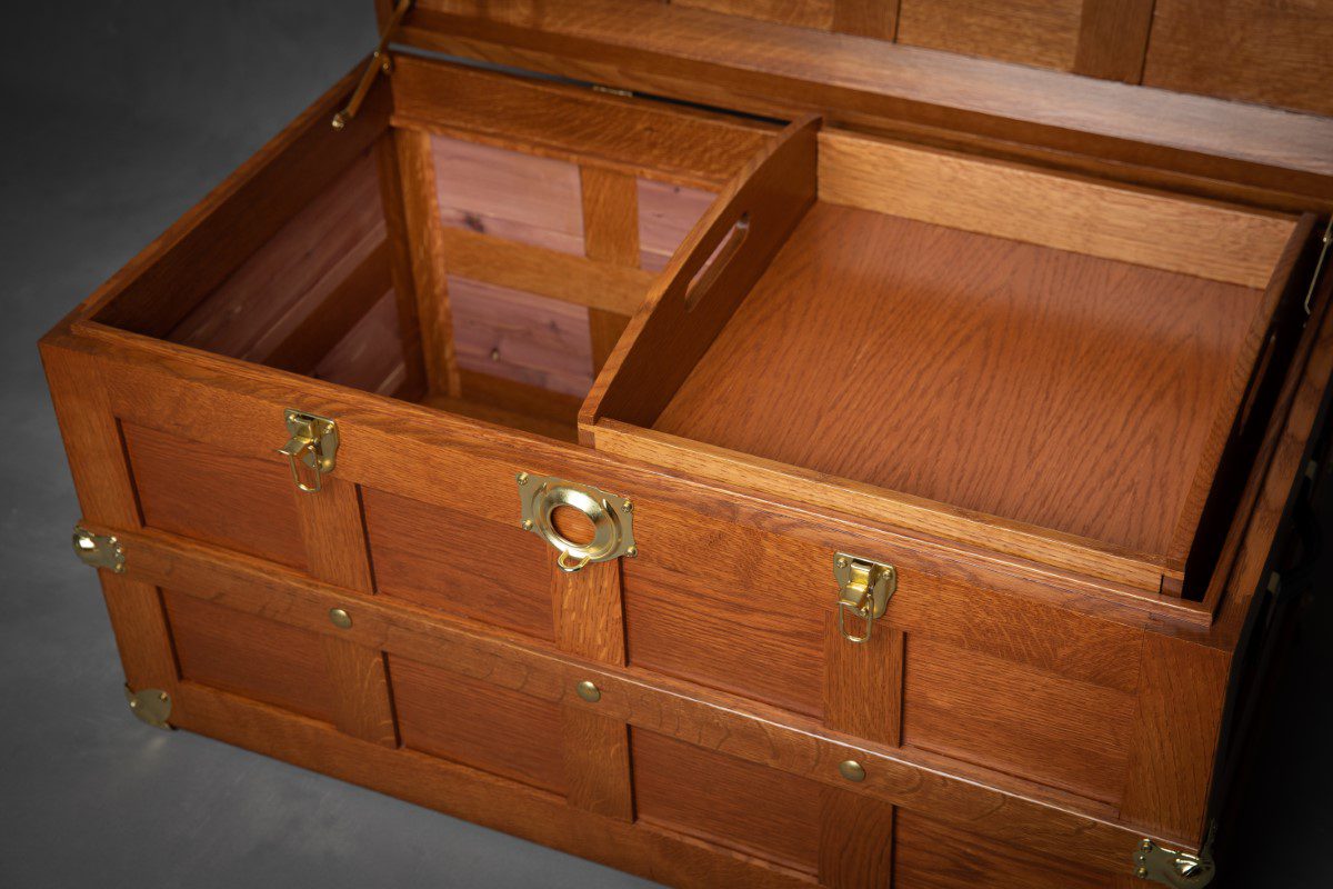 A wooden trunk with two drawers and one lid open.