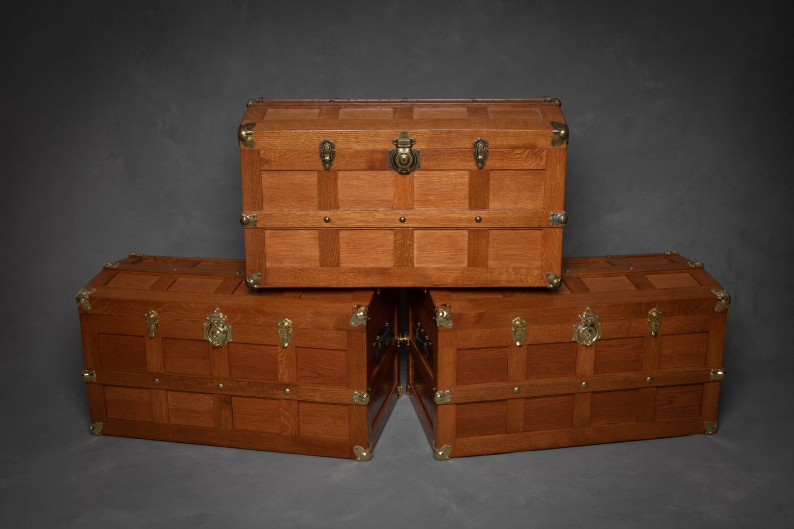 Three wooden trunks are stacked on top of each other.