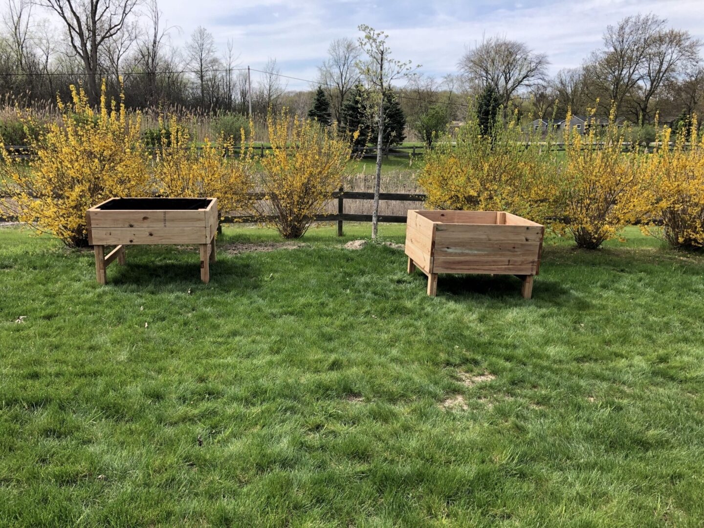 Two wooden planters in a field of grass