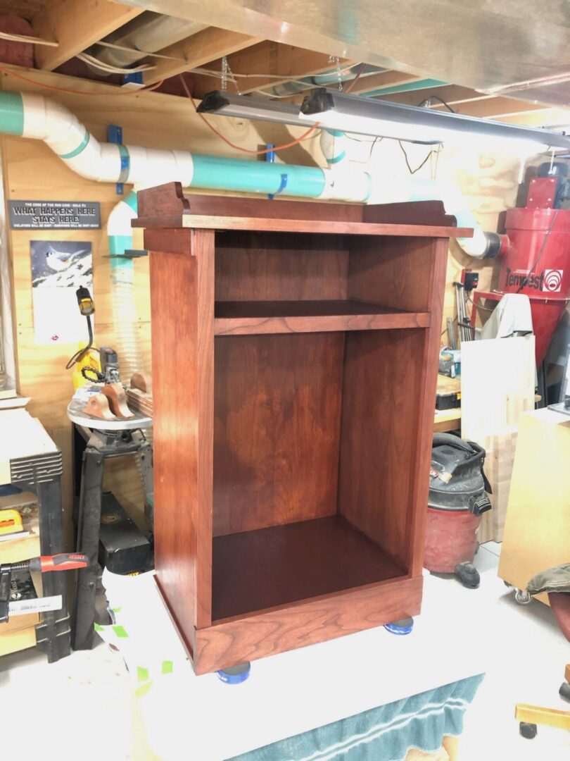 A wooden cabinet in the middle of a room.