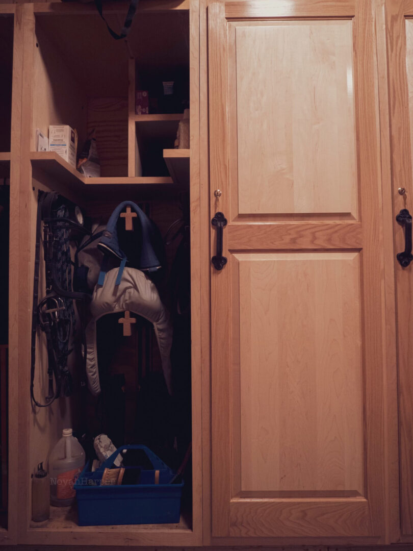 A closet with many wooden doors and shelves.